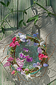 Wreath of willow branches and sweet peas on a glass bowl