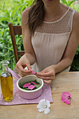 Malvenbreiumschlag zubereiten: Malvenblätter und Malvenblüten in eine Schale geben