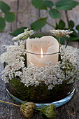 Wreath of Queen Anne's lace flowers arranged around candle lantern