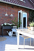 Terrasse mit Hortensien im kleinen Hochbeet an der Hauswand