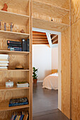Bücherregal aus Sperrholz als Raumteiler mit Blick ins Schlafzimmer