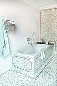 Bathtub in bathroom with mosaic tiles