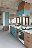 Modern kitchen with turquoise cabinet fronts and concrete ceiling