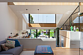 Modern gestaltetes Wohnzimmer mit Küche im Loft-Stil und großen Fenstern