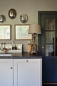 A table lamp with an angel stand next to the sink in a classic grey kitchen