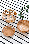 Three baskets on black-and-white striped rug