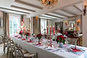 Festlich gedeckter Tisch in Rot und Weiß im eleganten Wohnraum