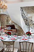 Festlich gedeckter Tisch in Rot und Weiß im eleganten Landhaus