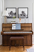 Black-and-white family photos above piano