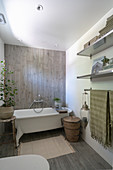 A freestanding bathtub in front of a wooden wall in a bathroom