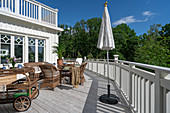 A sunny terrace with rattan furniture and a serving trolley