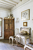 Shell collection on antique wooden table, chairs and corner cabinet with bust in bathroom