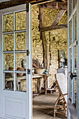 Blick durch geöffnete Tür ins Zimmer mit Natursteinwand
