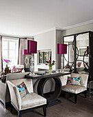 Cushions on armchairs with console and mirrored cabinet