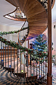 Christmas tree in hallway with walnut pillars support floating cantilevered stairs