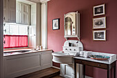 Built-in bathtub in an alcove in classic bathroom with pink wall