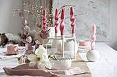 Artistically twisted candles on table set for Easter meal