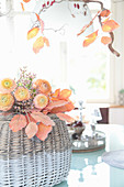 Bouquet of apricot ranunculus and sea lavender on artificial autumn leaves
