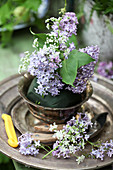 Arranging a bouquet of lilac and cow parsley in florists' foam