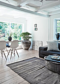 Offener Wohnraum mit Holzdielenboden, Esstisch mit Klassikerstühlen im Hintergrund