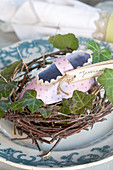 Homemade paper baby shoe in a nest as place cards