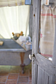 an open door with window and patina, with a view into a nostalgic bathroom
