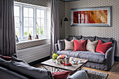 Two sofas facing one another in living room with graphic wallpaper