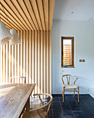 Wood-clad walls and ceiling in dining area of open-plan interior