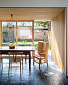 Wood-clad walls and ceiling in dining area of open-plan interior