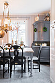 Rustikaler, gedeckter Esstisch und graue Anrichte in weihnachtlich dekorierter Wohnküche