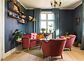 Mid-century furniture upholstered in red in living room with blue walls