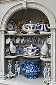Blue and white striped service on shelves in arched niche