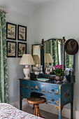Three-piece vanity mirror on blue dresser in bedroom