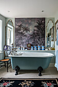 Wallpaper with palm-tree motif above free-standing bathtub