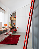 Rote Leiter an grauer Wand, Schreibtisch vorm Einbauschrank