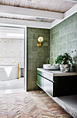 Olivgrüner Waschtisch mit Betonplatte und passende Wandlfiesen im Badezimmer