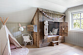 Play tent, chair and wooden cubby bed in child's bedroom