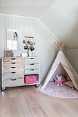 Chest of drawers on castors and play tent in child's bedroom