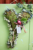Herz aus Moos und Hortensienblüten mit Efeublättern und Zwiebel