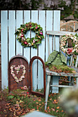 Autumn wreaths made of moss, ivy, onions, sedum, and snowberries, a heart made of snowberries in an old lantern