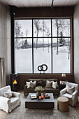 Cosy living room in natural colours with view of snowy landscape