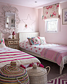 Twin beds and laundry baskets with floral roman blinds