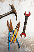 Hammer, tin snips and wrench on metal surface