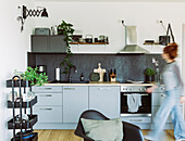 Pale grey kitchen counter, shell chair and shelves