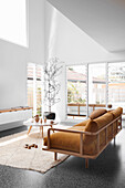 Brown sofa with velvet upholstery and coffee table in bright, high living room