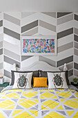Various geometric patterns in the bedroom and scatter cushions with beetle motifs on bed