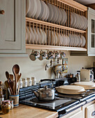 Wooden plate rack above stove with kettle on hob