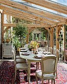 Dining room in glass conservatory extension of 19th century stone farmhouse.