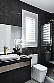 Marble tiles in modern, masculine bathroom decorated in black and grey
