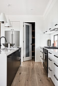 Offene Tür zur Vorratskammer in klassischer Küche in Schwarz-Weiß